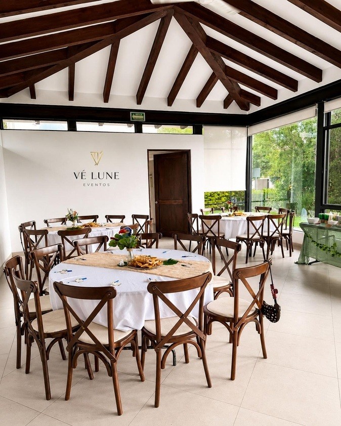 Salón de Vé Lune Eventos con mesas redondas y sillas Crossback montadas